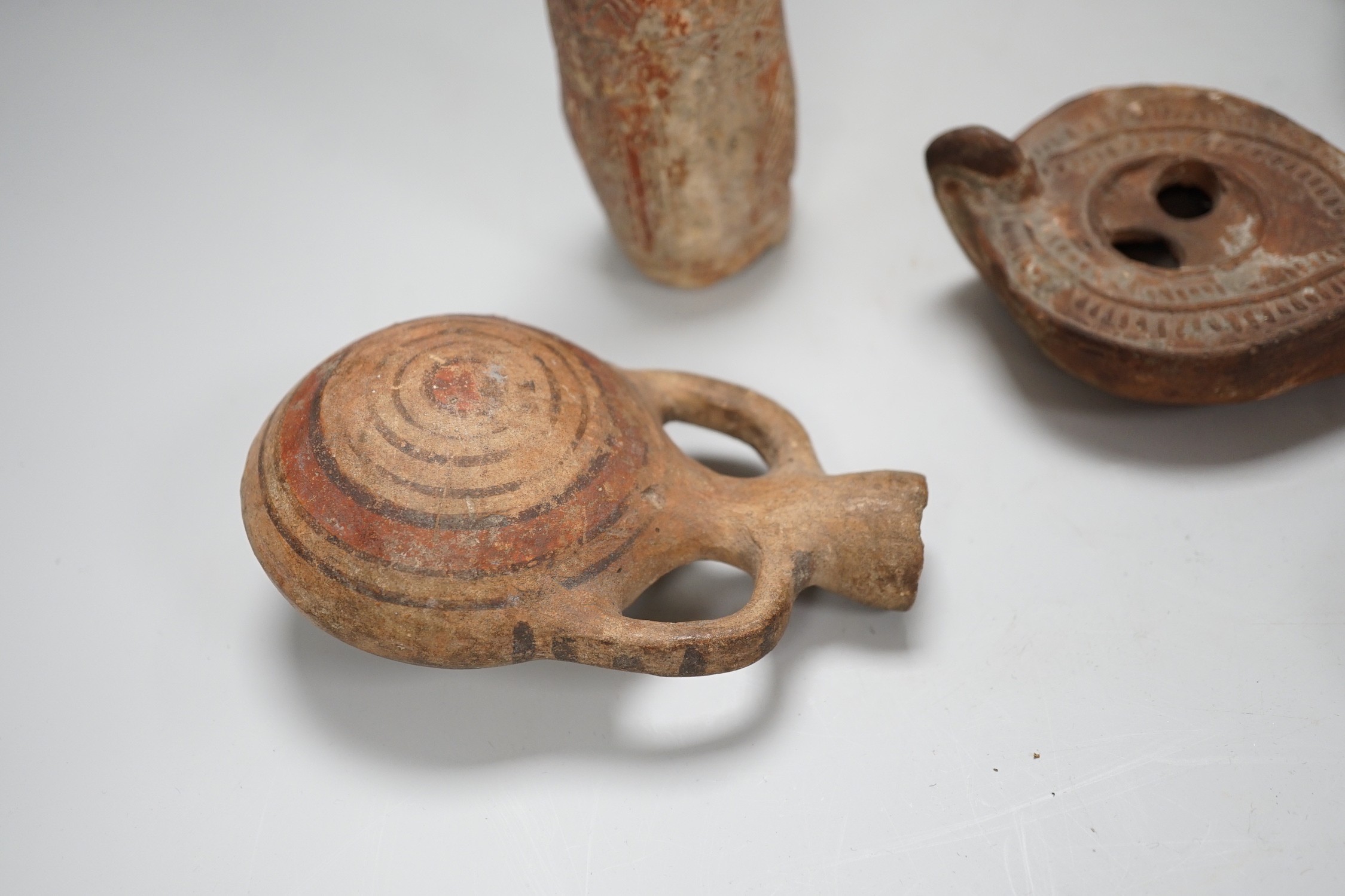 An Apulian black painted kylix, c. 4th century BCE., a Cypriot pottery flask, early Iron Age, two Roman terracotta oil lamps and another archaic vessel, tallest 14cm